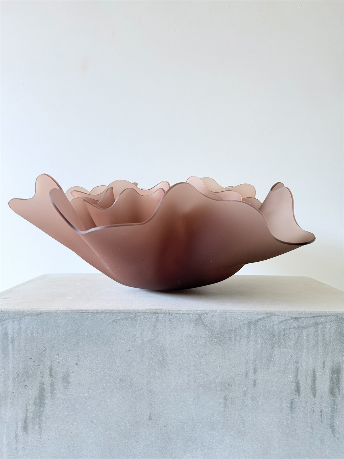Triple Peony, a sculptural lamp by Bec Stevens in Frosted Mocha, as a bowl on a concrete plinth