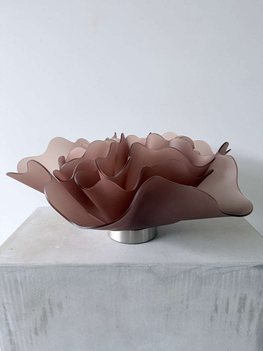 Triple Peony, a sculptural lamp by Bec Stevens in Frosted Mocha, on its lamp base on a concrete plinth